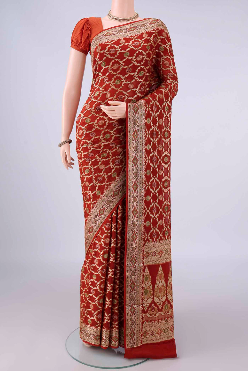 Rust Blended Banarasi Georgette Saree with Thread Brocade on the body and Zari And Thread Border.  displayed on a mannequin