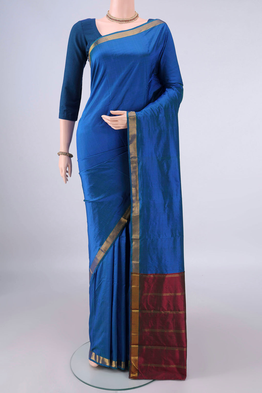 Pure Silk Peacock Blue Kanchipuram Saree with Plain Body and Zari Border.  displayed on a mannequin