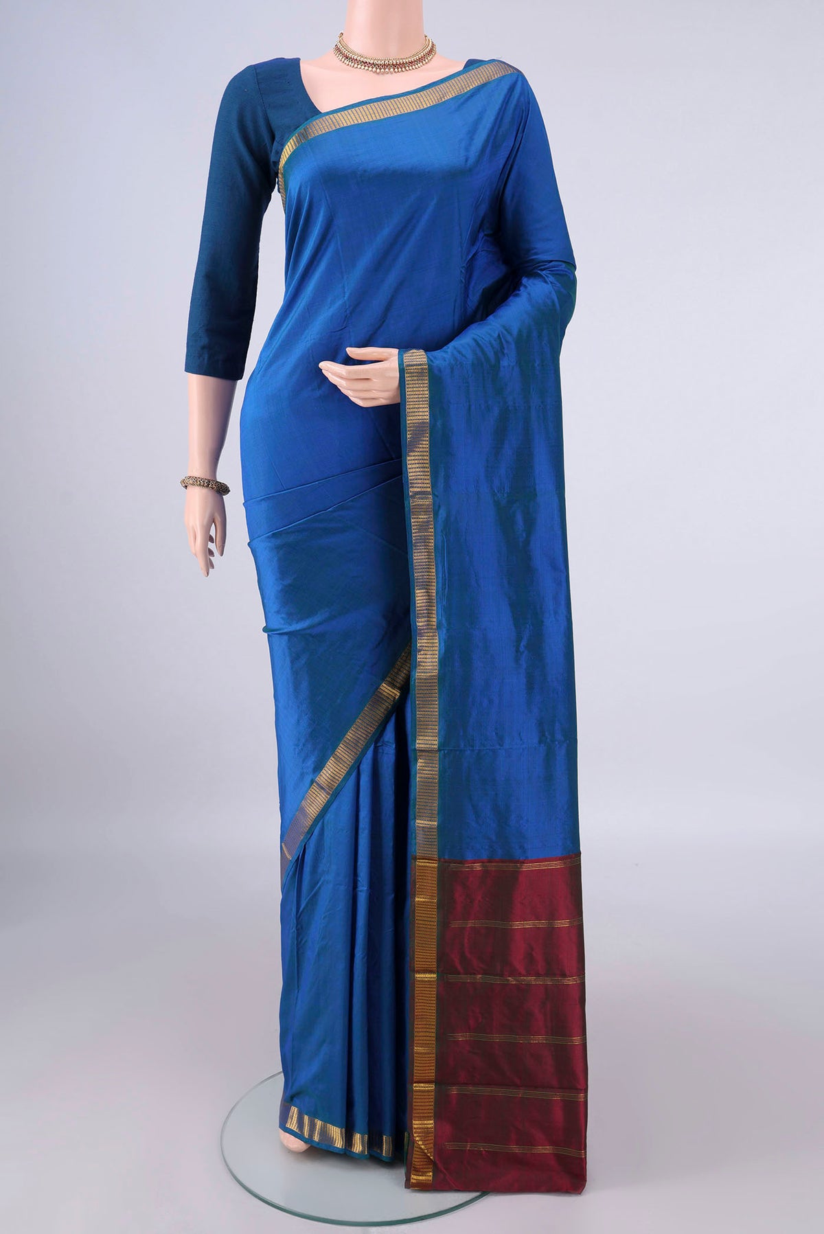 Pure Silk Peacock Blue Kanchipuram Saree with Plain Body and Zari Border.  displayed on a mannequin