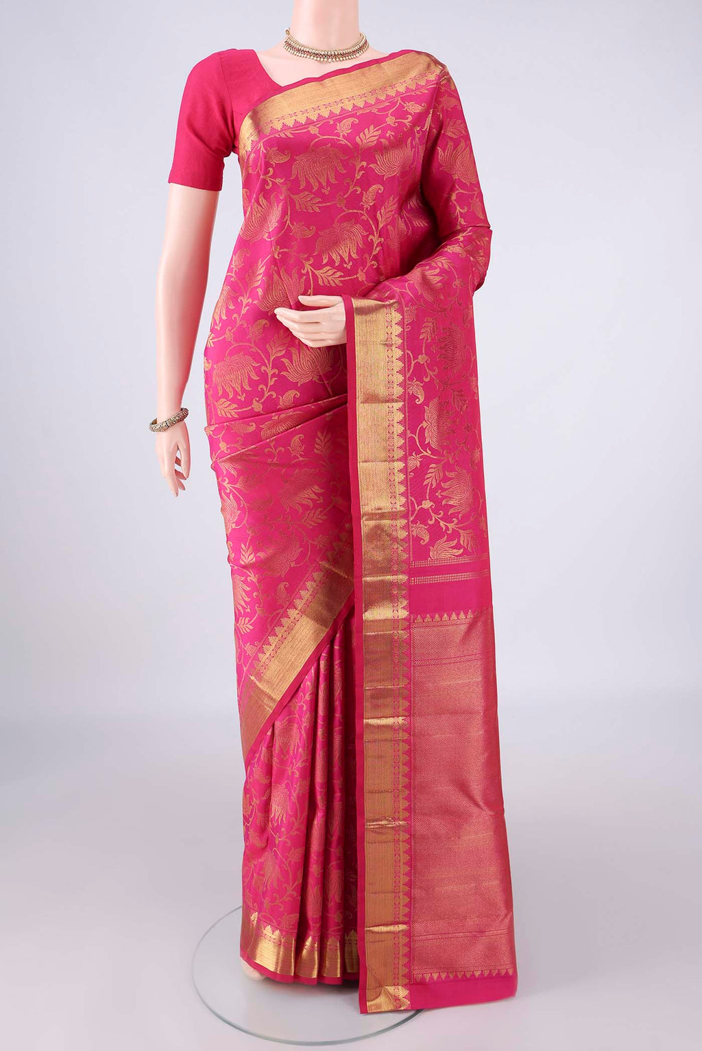 Pure Silk Rani Pink Kanchipuram Saree with Zari Brocade on the body and Zari Border.  displayed on a mannequin