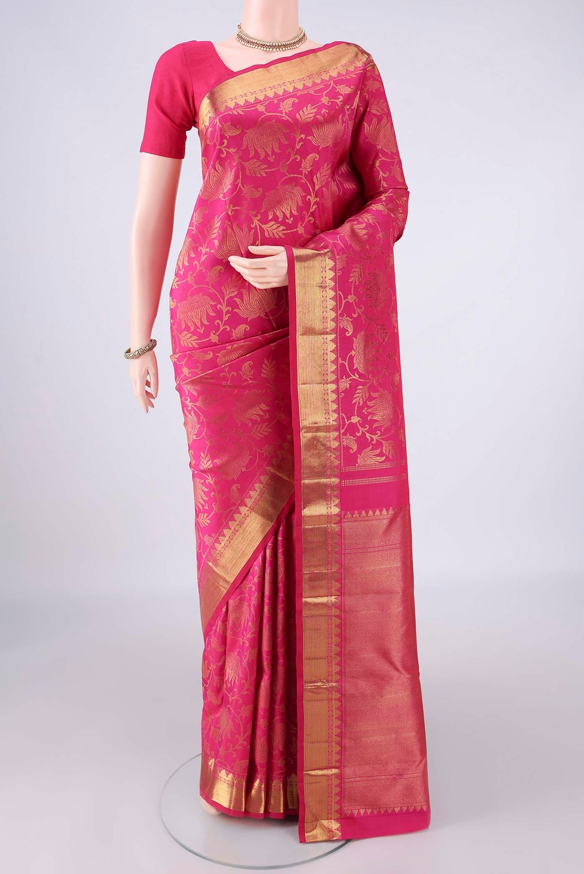 Pure Silk Rani Pink Kanchipuram Saree with Zari Brocade on the body and Zari Border.  displayed on a mannequin