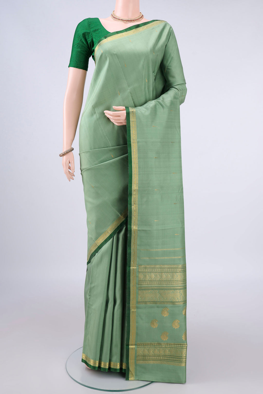 Pure Silk Pista Green Kanjivaram Saree with Zari Butta on the body and Zari Border.  displayed on a mannequin