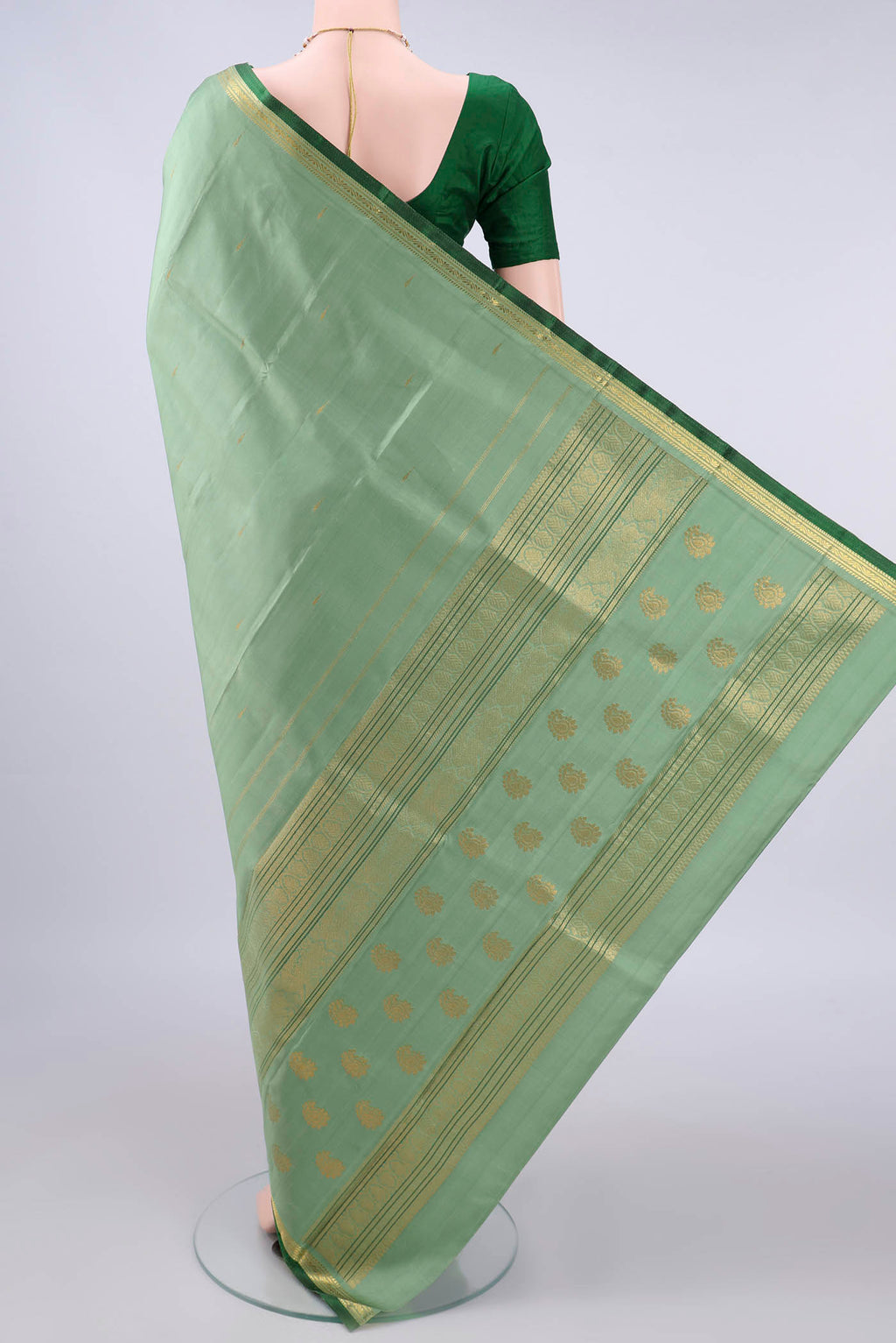 Flat view of Pure Silk Pista Green Kanjivaram Saree with Zari Butta on the body and Zari Border. 