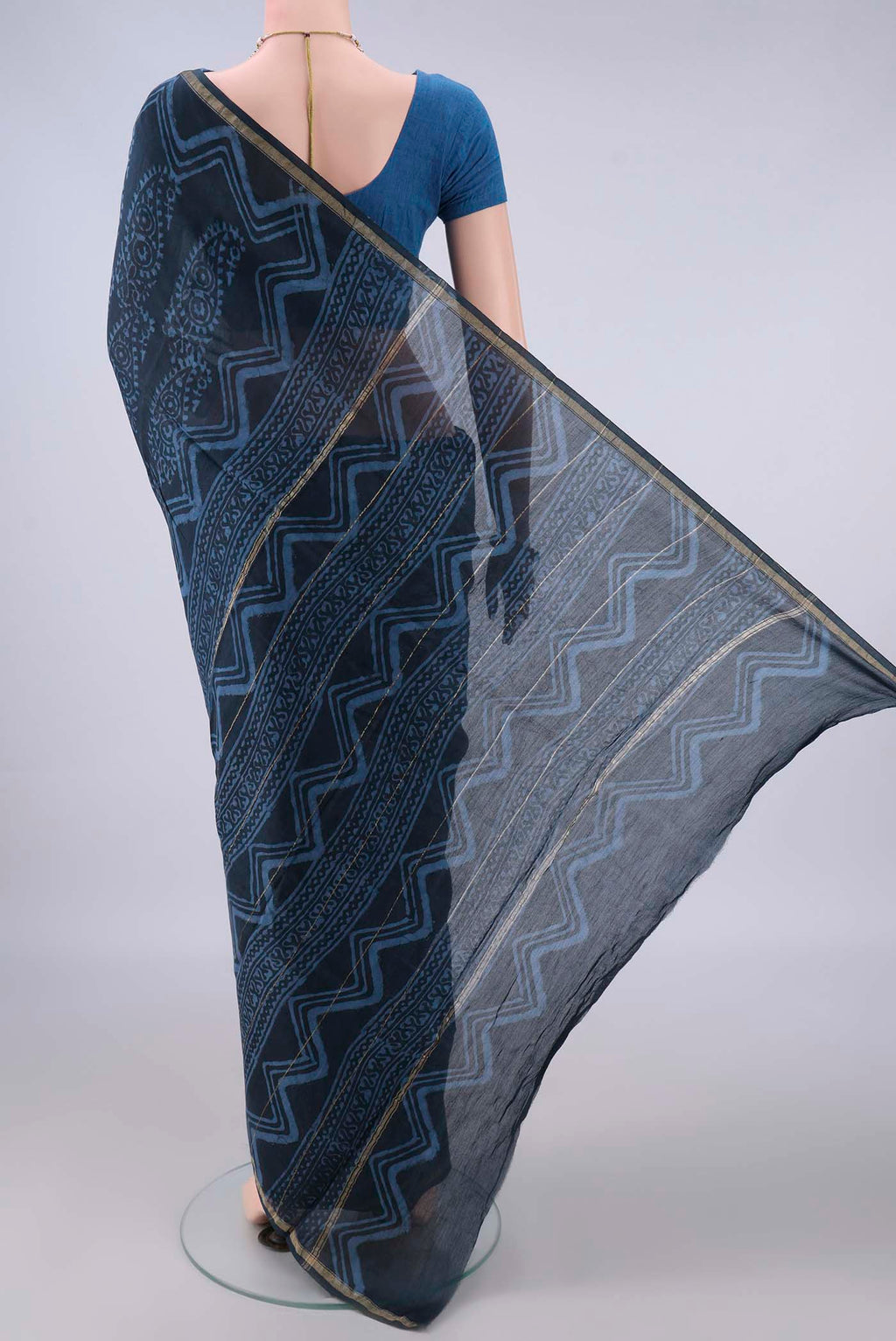 Flat view of Indigo Chanderi Cotton Saree with Batik Print on the body and Thin Zari Line. 
