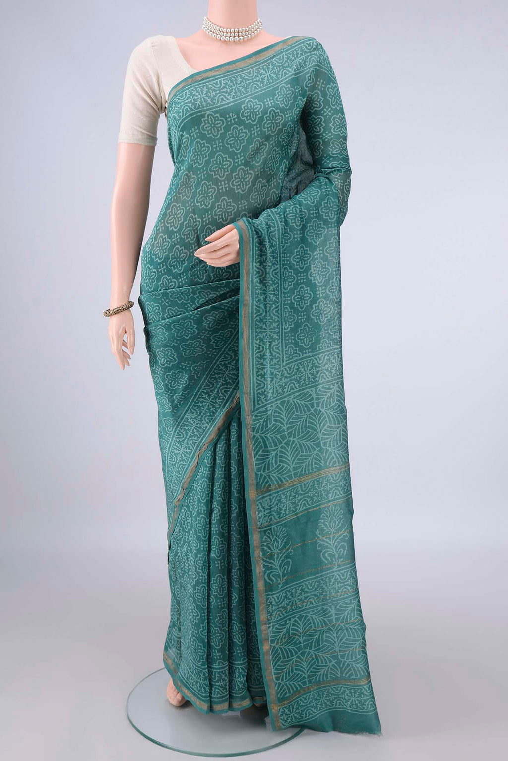 Green Chanderi Cotton Saree with Batik Print on the body and Thin Zari Line.  displayed on a mannequin