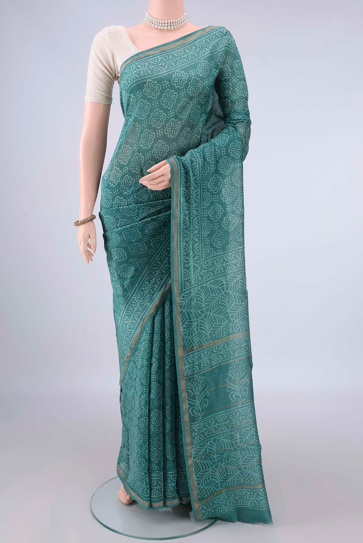 Green Chanderi Cotton Saree with Batik Print on the body and Thin Zari Line.  displayed on a mannequin