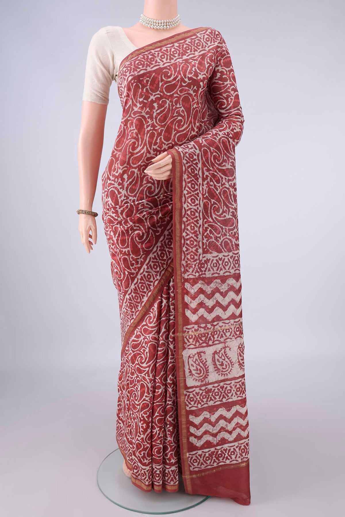Peach Chanderi Cotton Saree with Batik Print on the body and Thin Zari Line.  displayed on a mannequin
