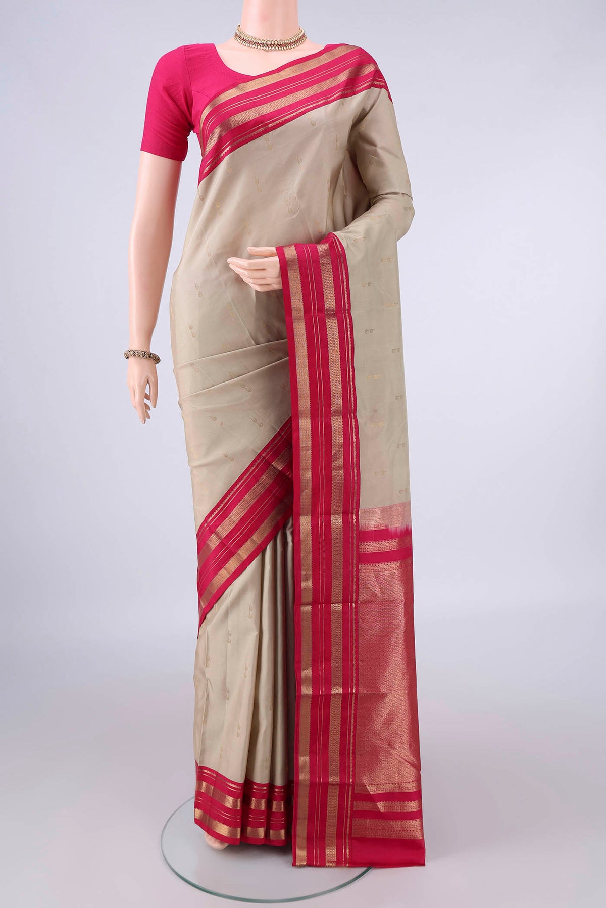 Pure Silk Beige Kanchipuram Saree with Zari Butta on the body and Zari Border.  displayed on a mannequin