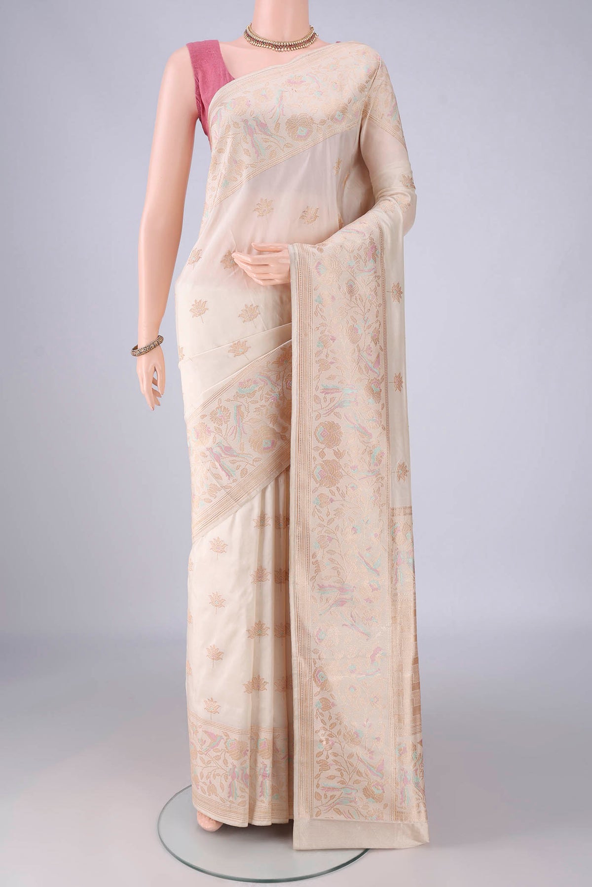 Pure Silk Off White Banarasi Saree with Zari And Thread Butta on the body and Meenakari Border.  displayed on a mannequin