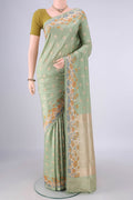 Pure Silk Pista Green Banarasi Saree with Zari Butta on the body and Meenakari Border.  displayed on a mannequin