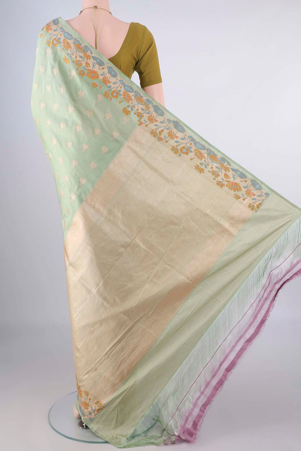 Flat view of Pure Silk Pista Green Banarasi Saree with Zari Butta on the body and Meenakari Border. 