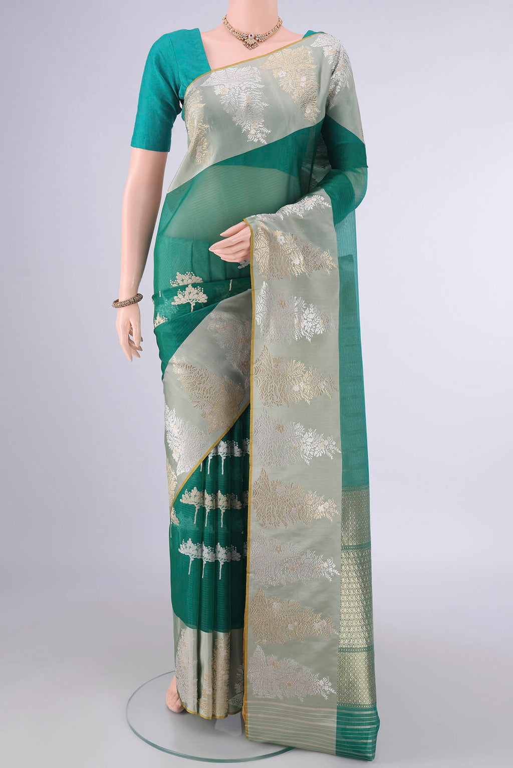 Pure Silk Sea Green Banarasi Kora Saree with Zari And Thread Butta on the body and Zari And Thread Border.  displayed on a mannequin