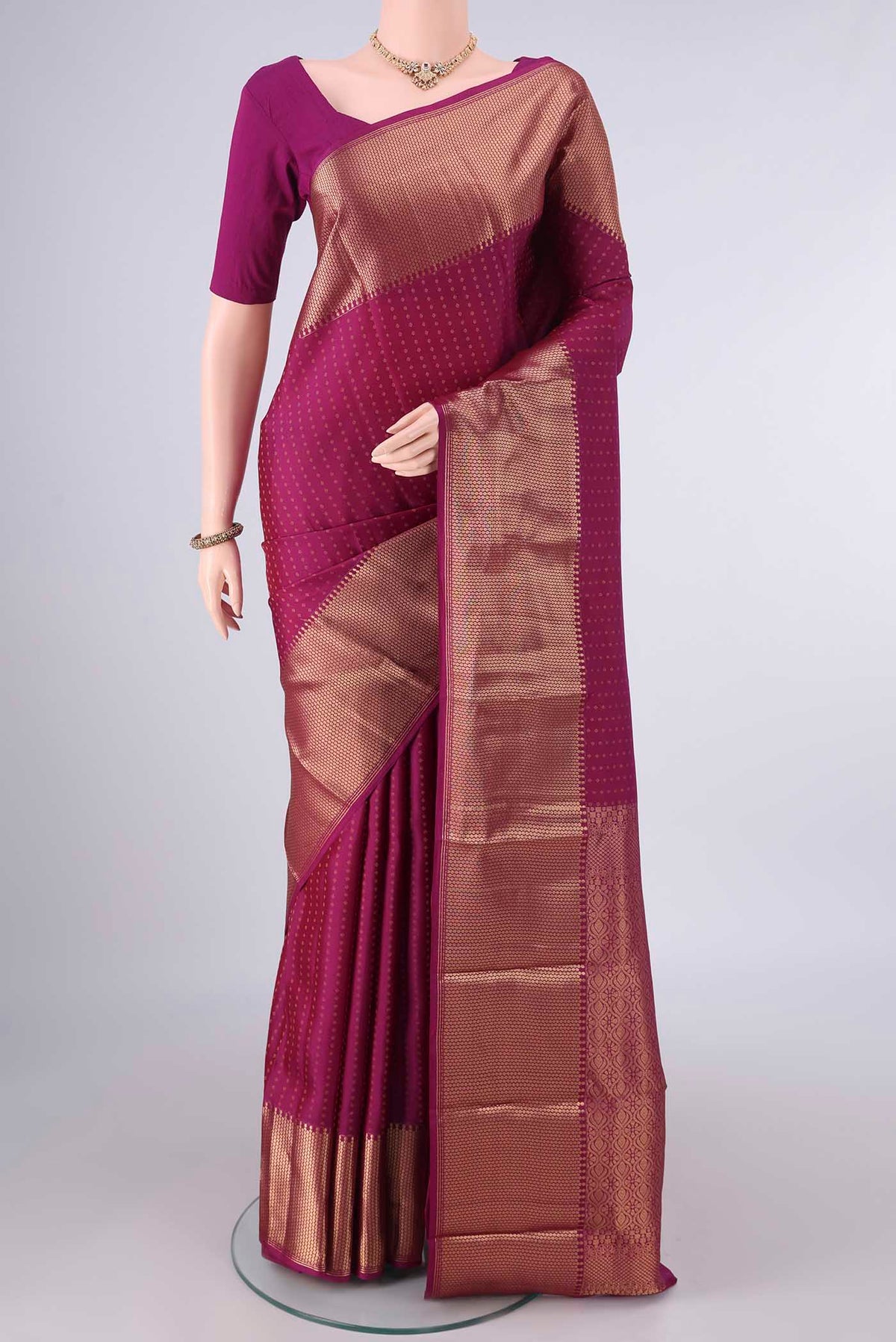 Pure Silk Magenta Kanjivaram Saree with Zari Butta on the body and Zari Border.  displayed on a mannequin