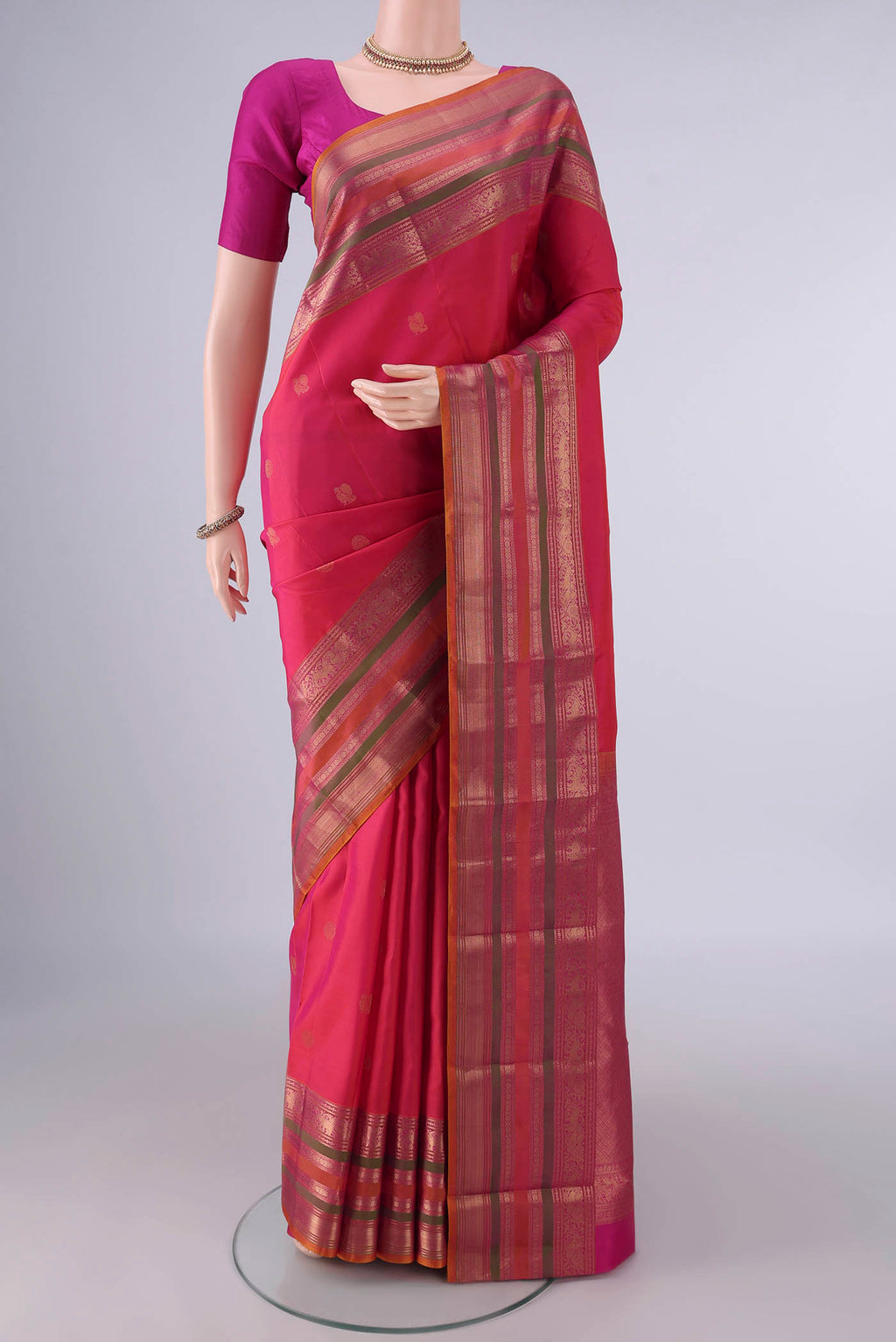 Pure Silk Coral Kanjivaram Saree with Zari Butta on the body and Zari Border.  displayed on a mannequin
