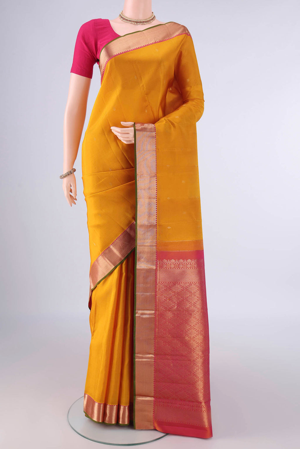 Pure Silk Mustard Kanjivaram Saree with Zari Butta on the body and Zari Border.  displayed on a mannequin