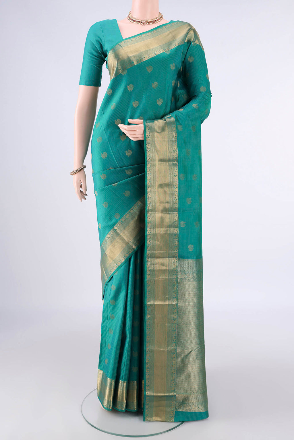 Pure Silk Sea Green Kanchipuram Saree with Zari Butta on the body and Zari Border.  displayed on a mannequin