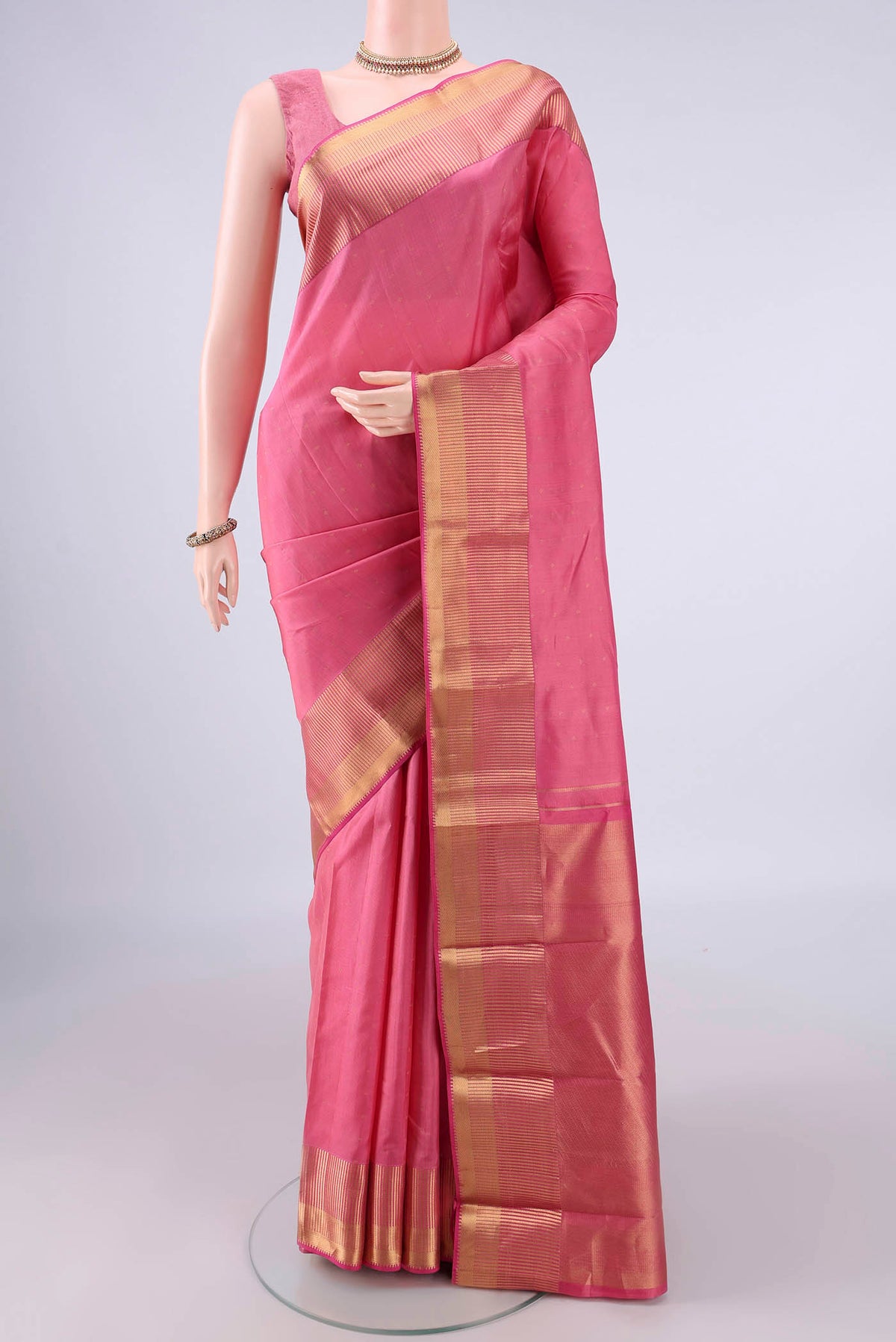 Pure Silk Coral Kanchipuram Saree with Zari Butta on the body and Zari Border.  displayed on a mannequin