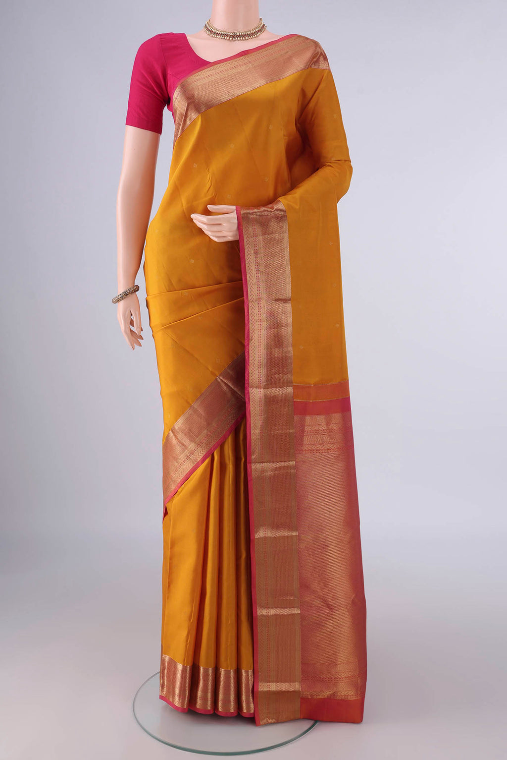 Pure Silk Mustard Kanchipuram Saree with Zari Butta on the body and Zari Border.  displayed on a mannequin