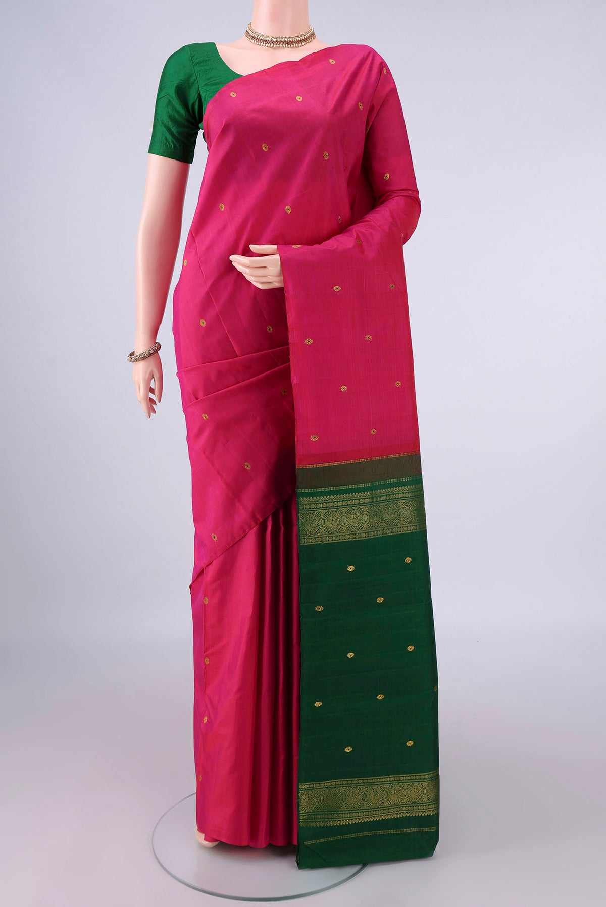 Pure Silk Rani Pink Kanchipuram Saree with Zari And Thread Butta on the body and Without Border.  displayed on a mannequin