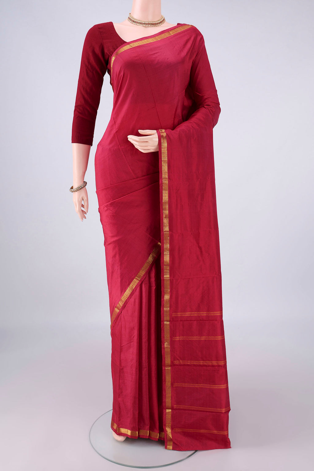 Pure Silk Maroon Kanchipuram Saree with Plain Body and Zari Border.  displayed on a mannequin