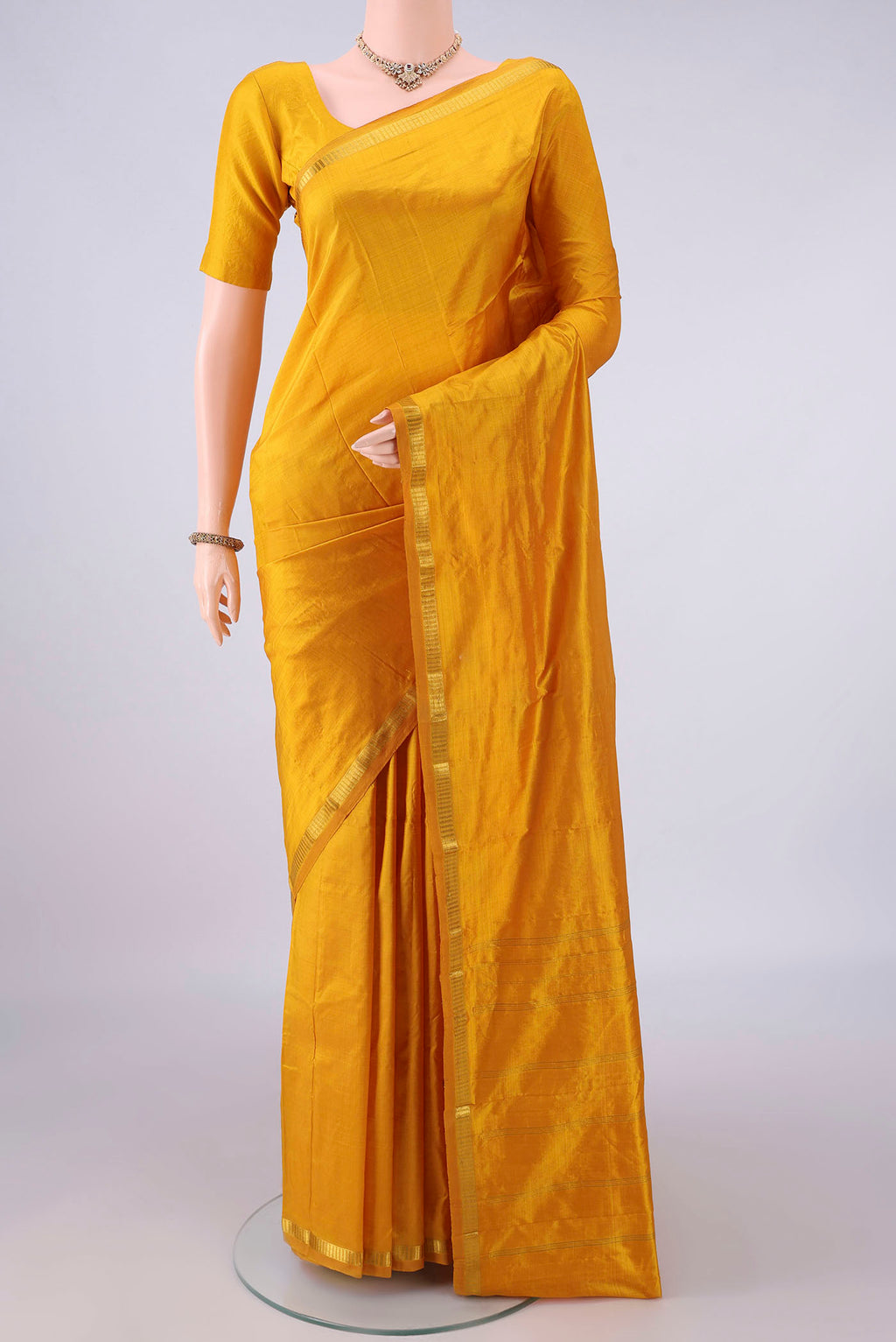 Pure Silk Yellow Kanchipuram Saree with Plain Body and Zari Border.  displayed on a mannequin