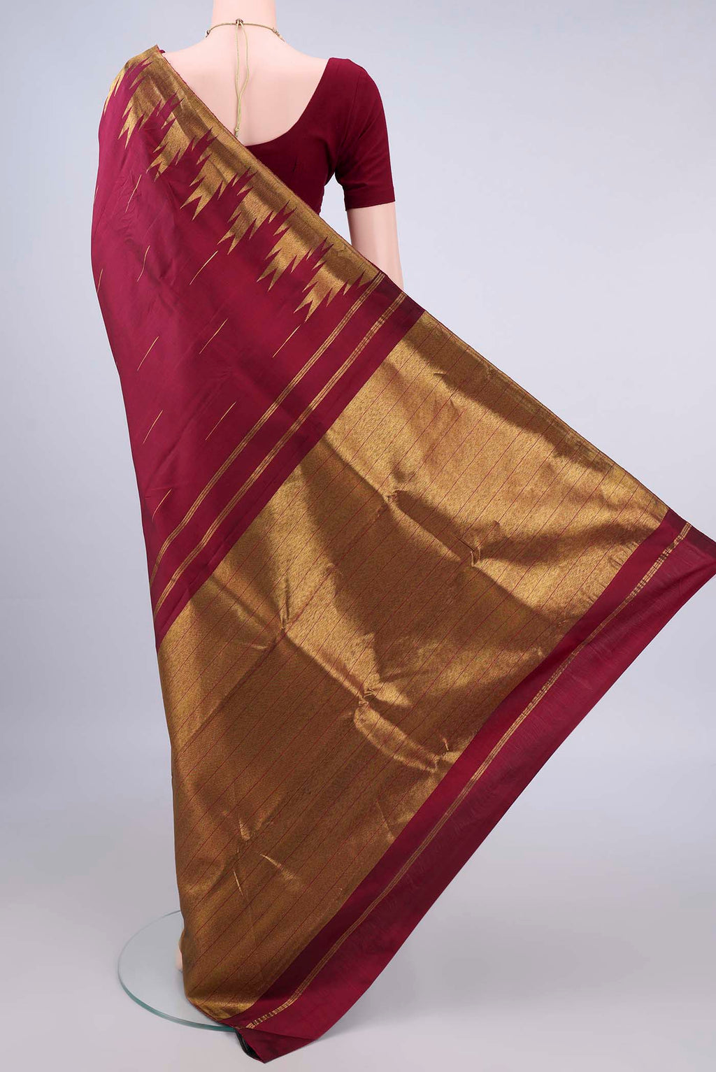 Flat view of Pure Silk Maroon Kanjivaram Saree with Zari Butta on the body and Temple Border. 