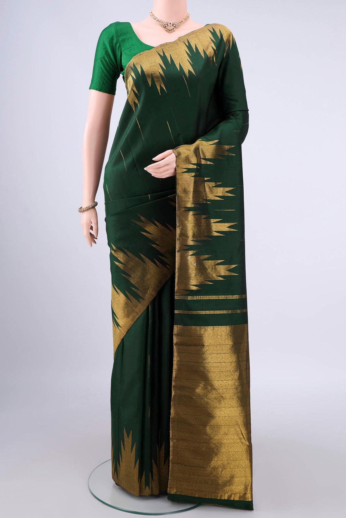 Pure Silk Bottle Green Kanjivaram Saree with Zari Butta on the body and Temple Border.  displayed on a mannequin