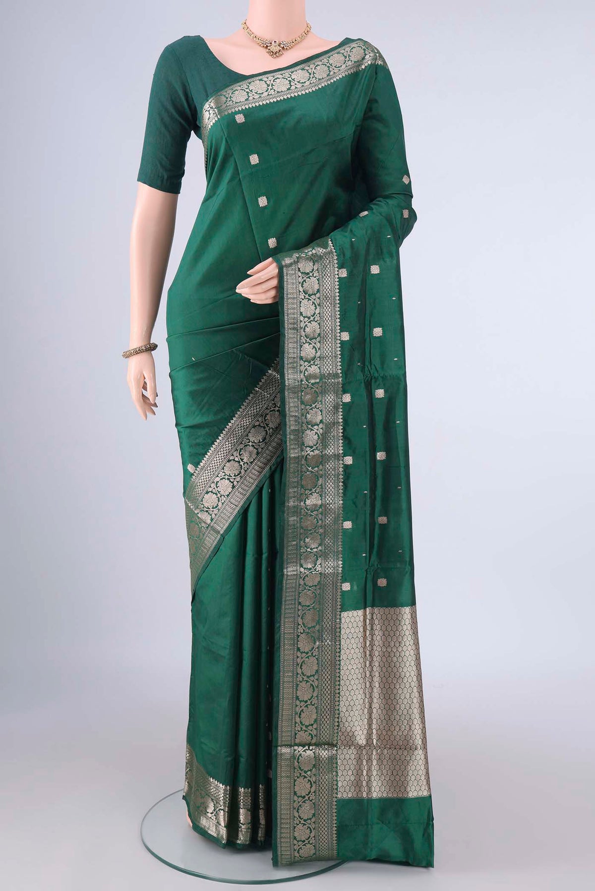 Pure Silk Bottle Green Banarasi Katan Saree with Zari Butta on the body and Zari Border.  displayed on a mannequin