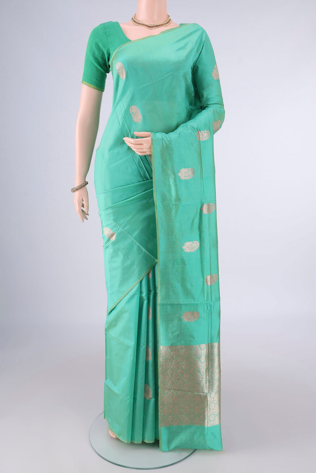 Pure Silk Green Banarasi Katan Saree with Zari Butta on the body and Without Border.  displayed on a mannequin