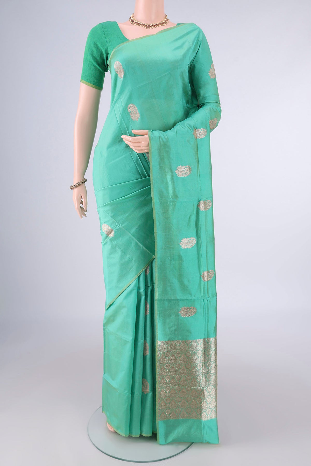 Pure Silk Green Banarasi Katan Saree with Zari Butta on the body and Without Border.  displayed on a mannequin