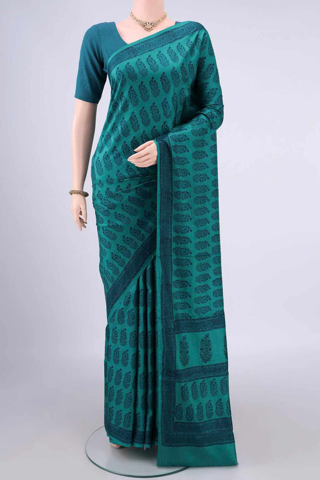 Pure Silk Teal Printed Saree with Printed design on the body and Printed Border.  displayed on a mannequin