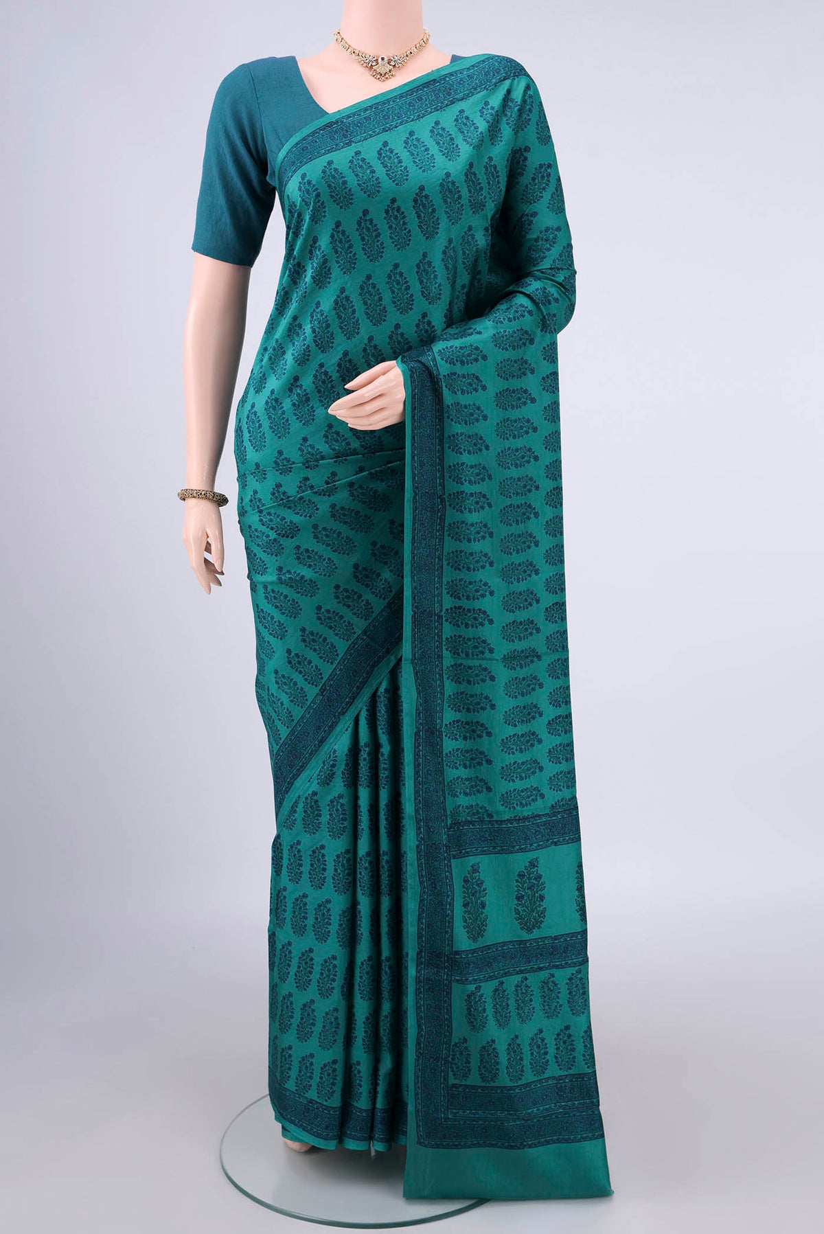 Pure Silk Teal Printed Saree with Printed design on the body and Printed Border.  displayed on a mannequin