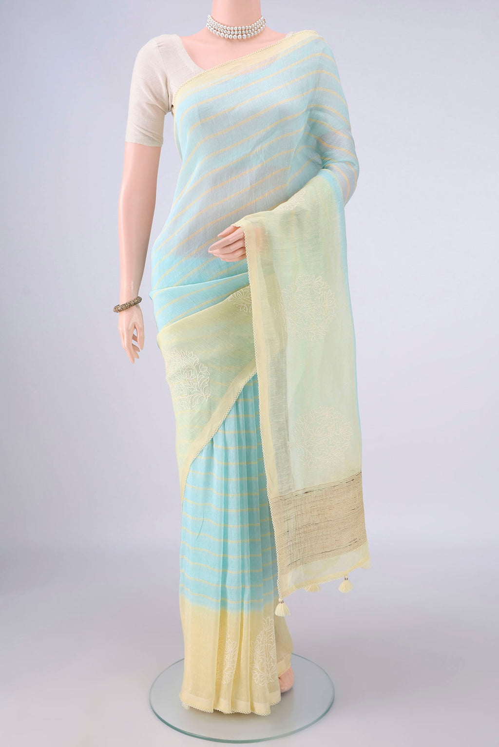 Sky Blue Linen Saree with Floral Print on the body and Without Border.  displayed on a mannequin