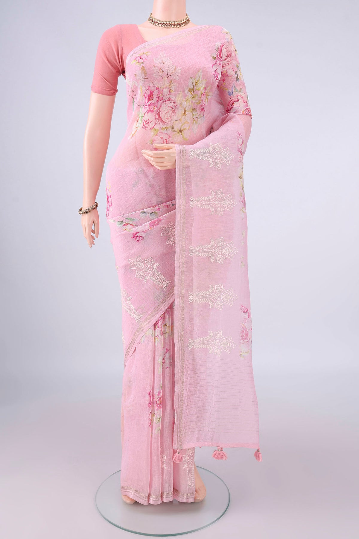 Rose pink Linen Saree with Floral Print on the body and Zari Border.  displayed on a mannequin