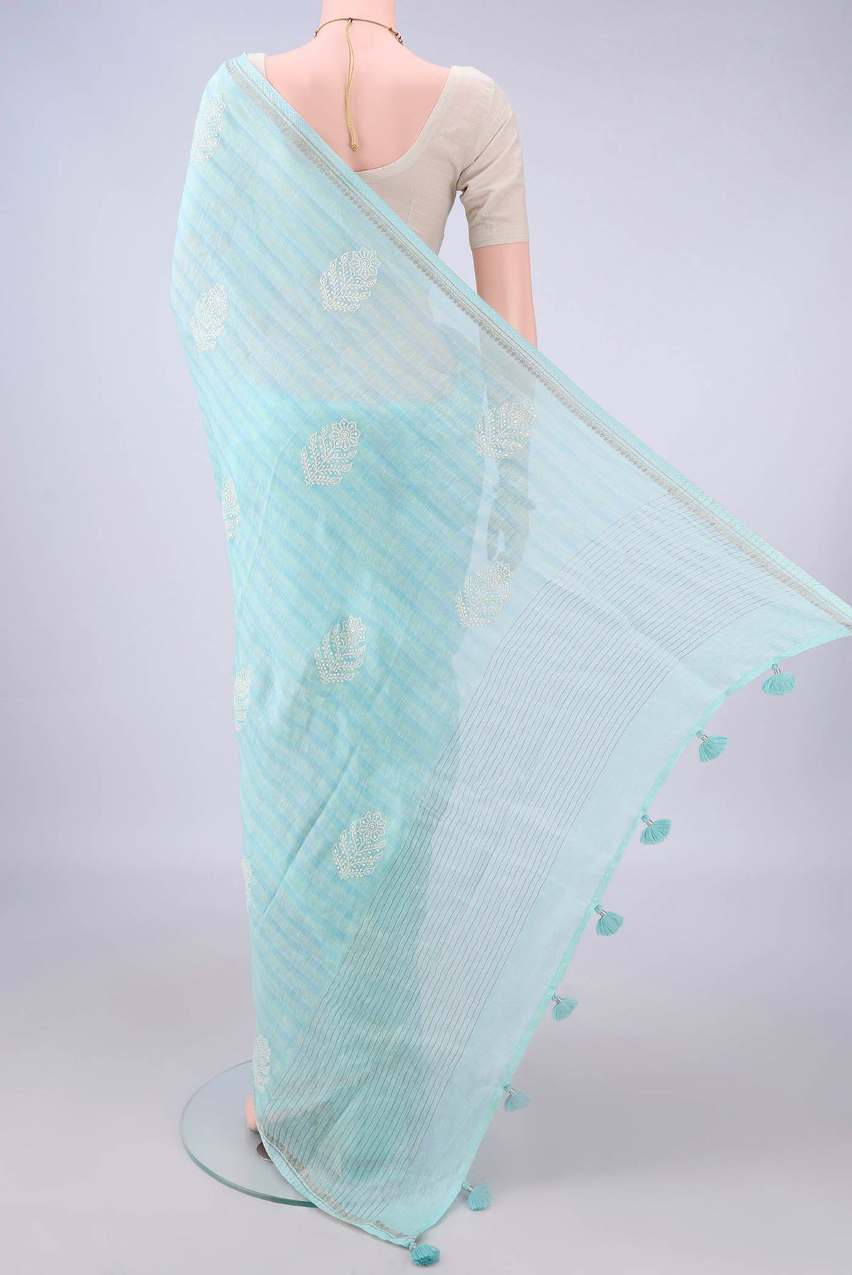 Flat view of Light Blue Linen Saree with Printed design on the body and Zari Border. 