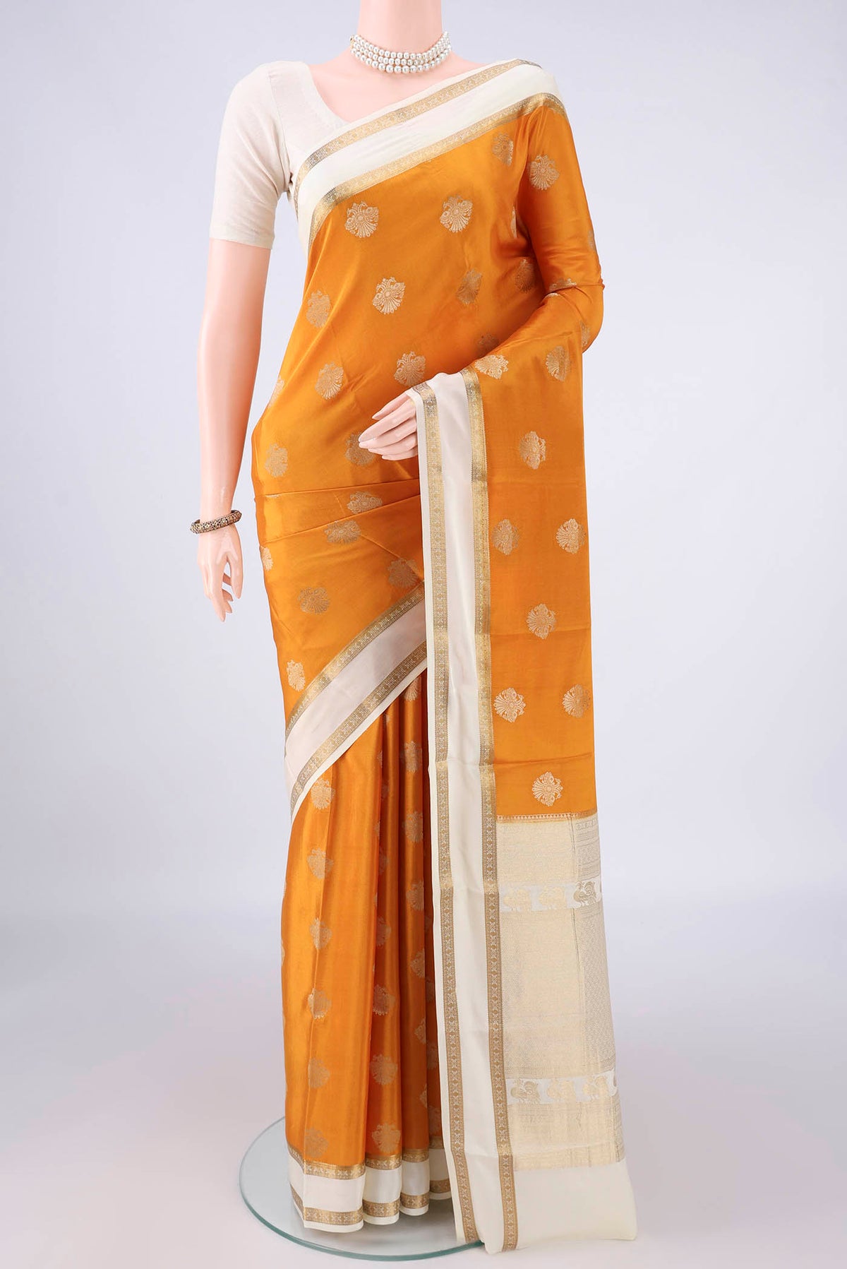 Mustard Mysore Crepe Saree with Zari Butta on the body and Zari Border.  displayed on a mannequin