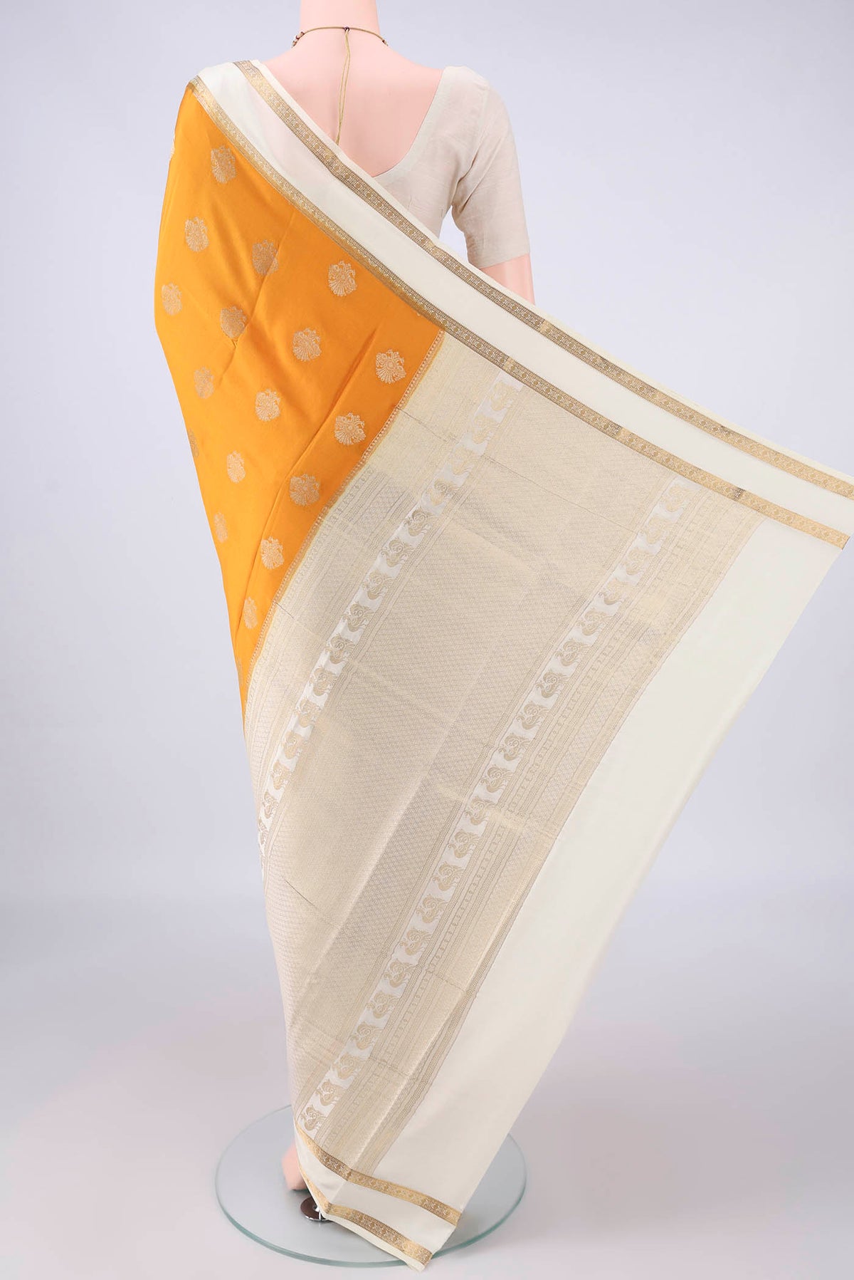 Flat view of Mustard Mysore Crepe Saree with Zari Butta on the body and Zari Border. 