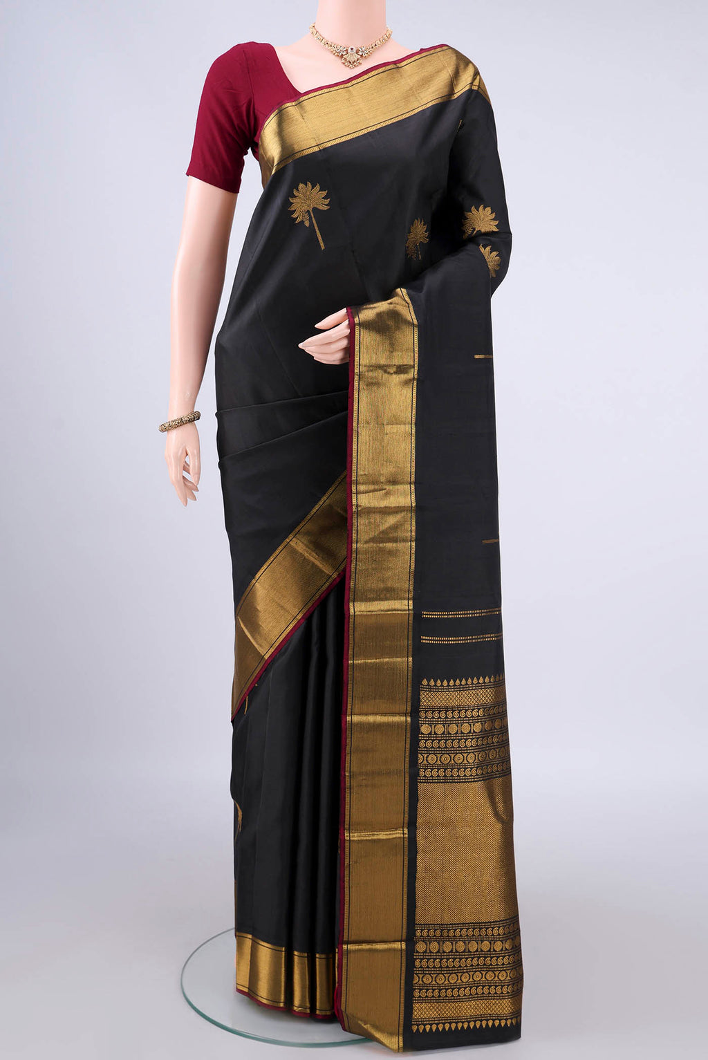Pure Silk Black Kanjivaram Saree with Zari Butta on the body and Zari Border.  displayed on a mannequin