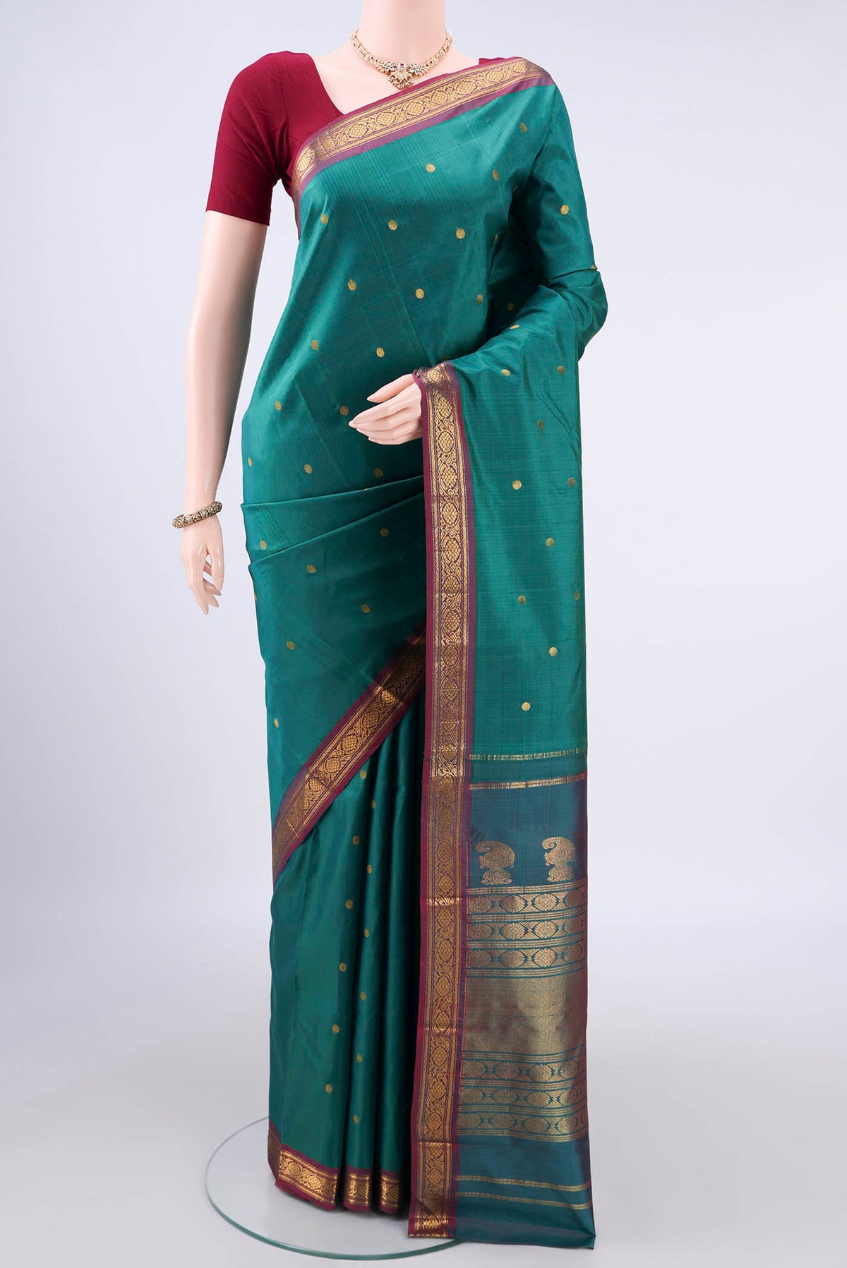 Pure Silk Sea Green Kanjivaram Saree with Zari Butta on the body and Zari Border.  displayed on a mannequin