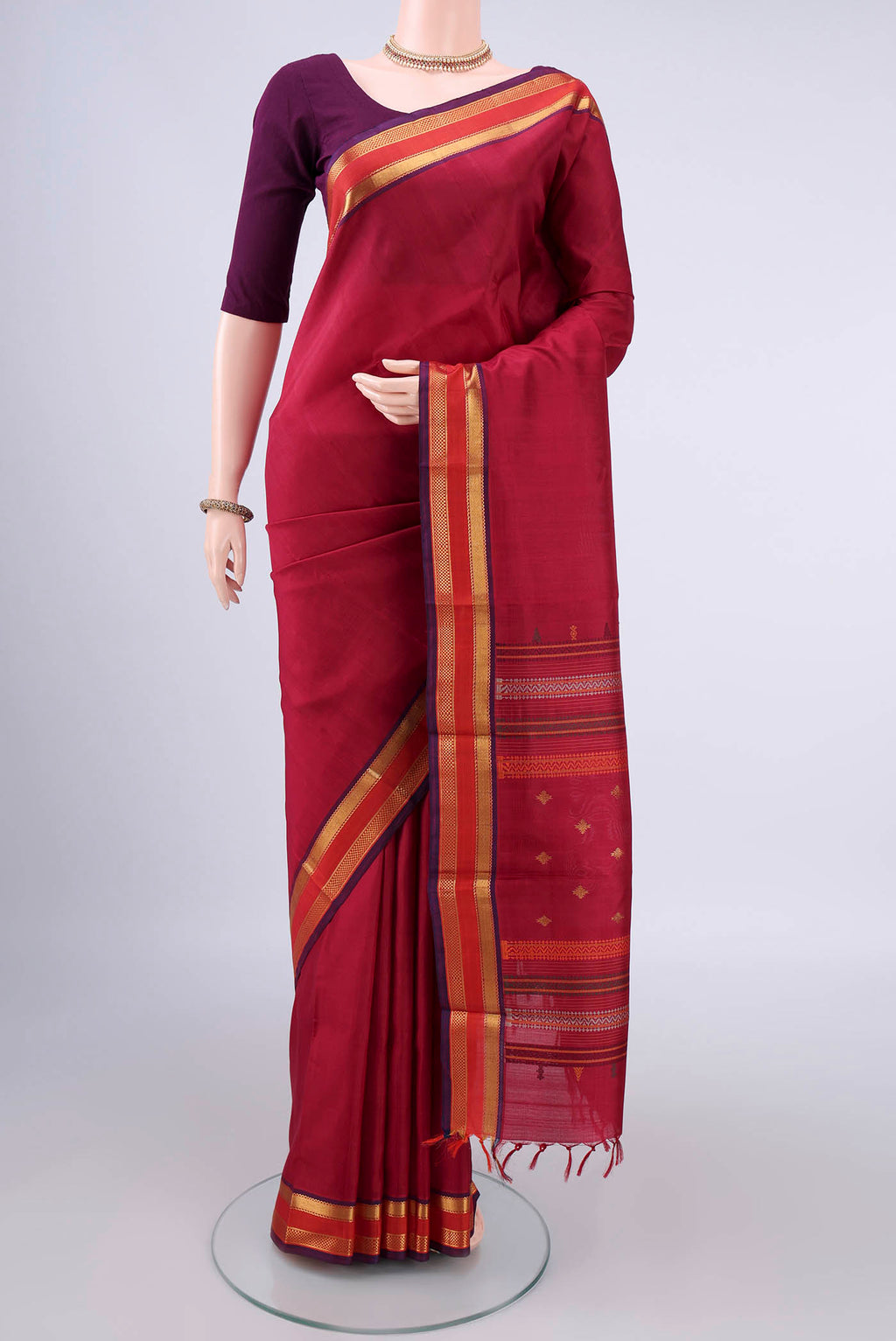 Pure Silk Red Kanchipuram Saree with Plain Body and Zari Border.  displayed on a mannequin