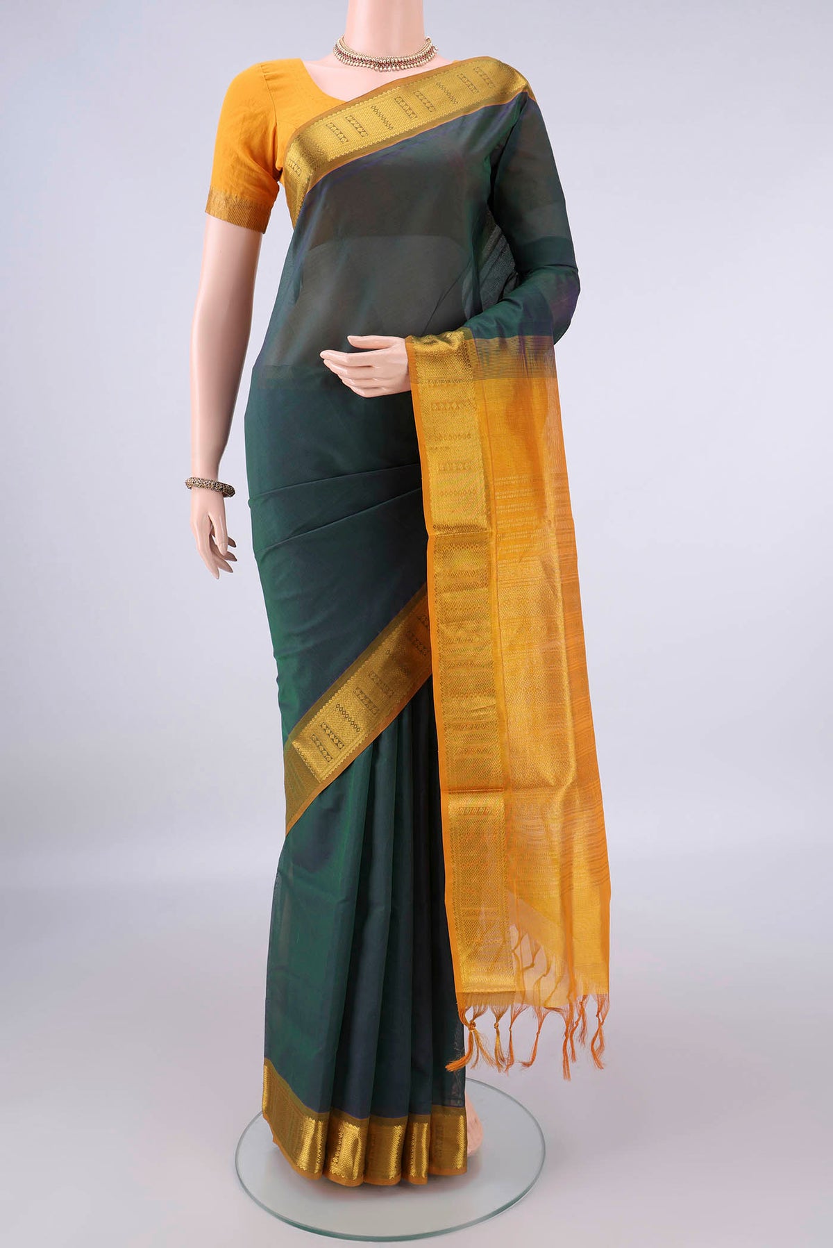 Bottle Green Silk Cotton Saree with Plain Body and Zari Border.  displayed on a mannequin