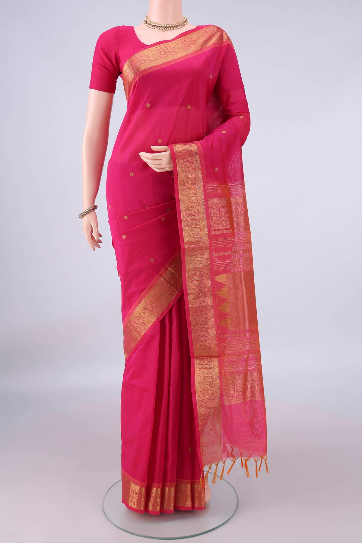 Rani Pink Silk Cotton Saree with Zari Butta on the body and Zari Border.  displayed on a mannequin