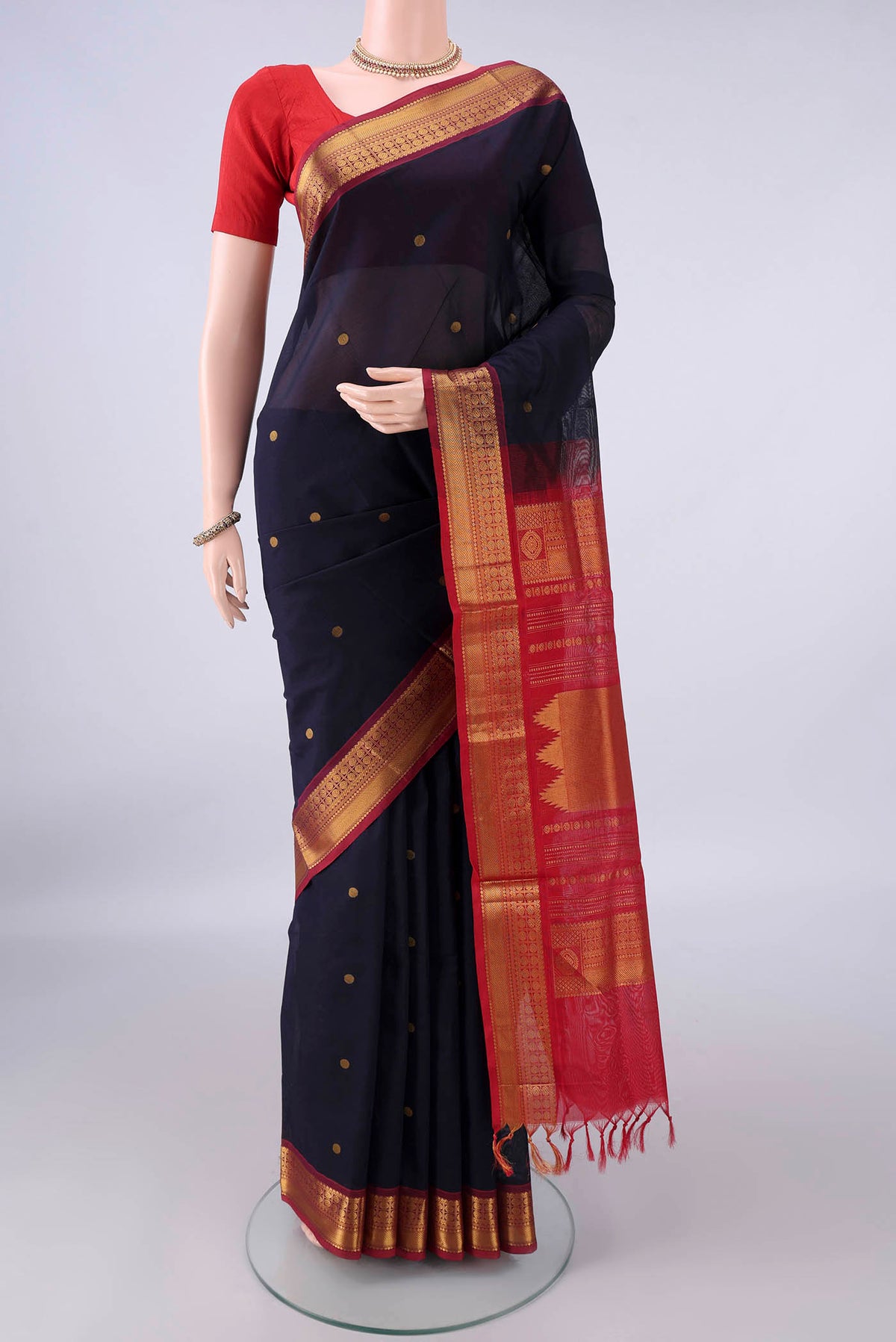 Navy Blue Silk Cotton Saree with Zari Butta on the body and Zari Border.  displayed on a mannequin