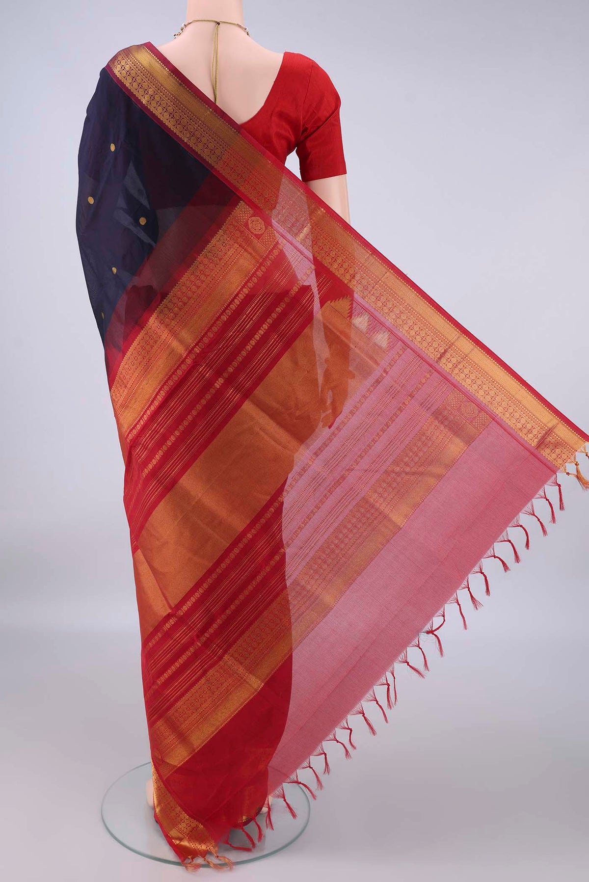 Flat view of Navy Blue Silk Cotton Saree with Zari Butta on the body and Zari Border. 