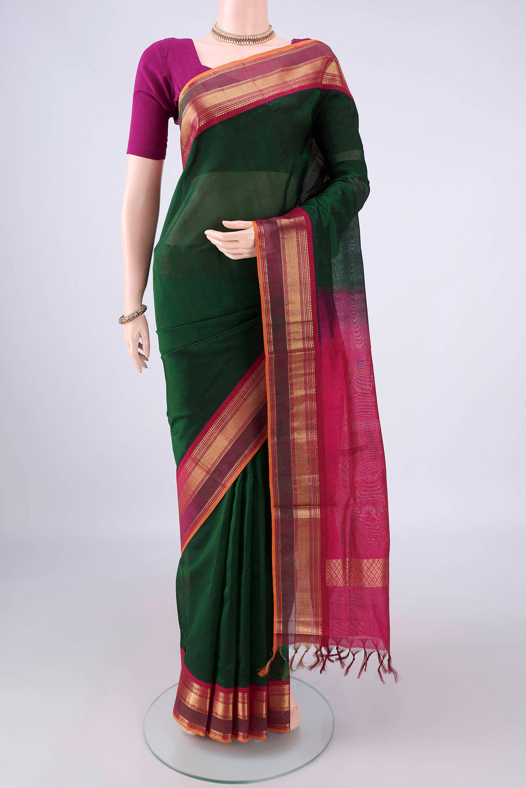 Bottle Green Silk Cotton Saree with Plain Body and Zari Border.  displayed on a mannequin