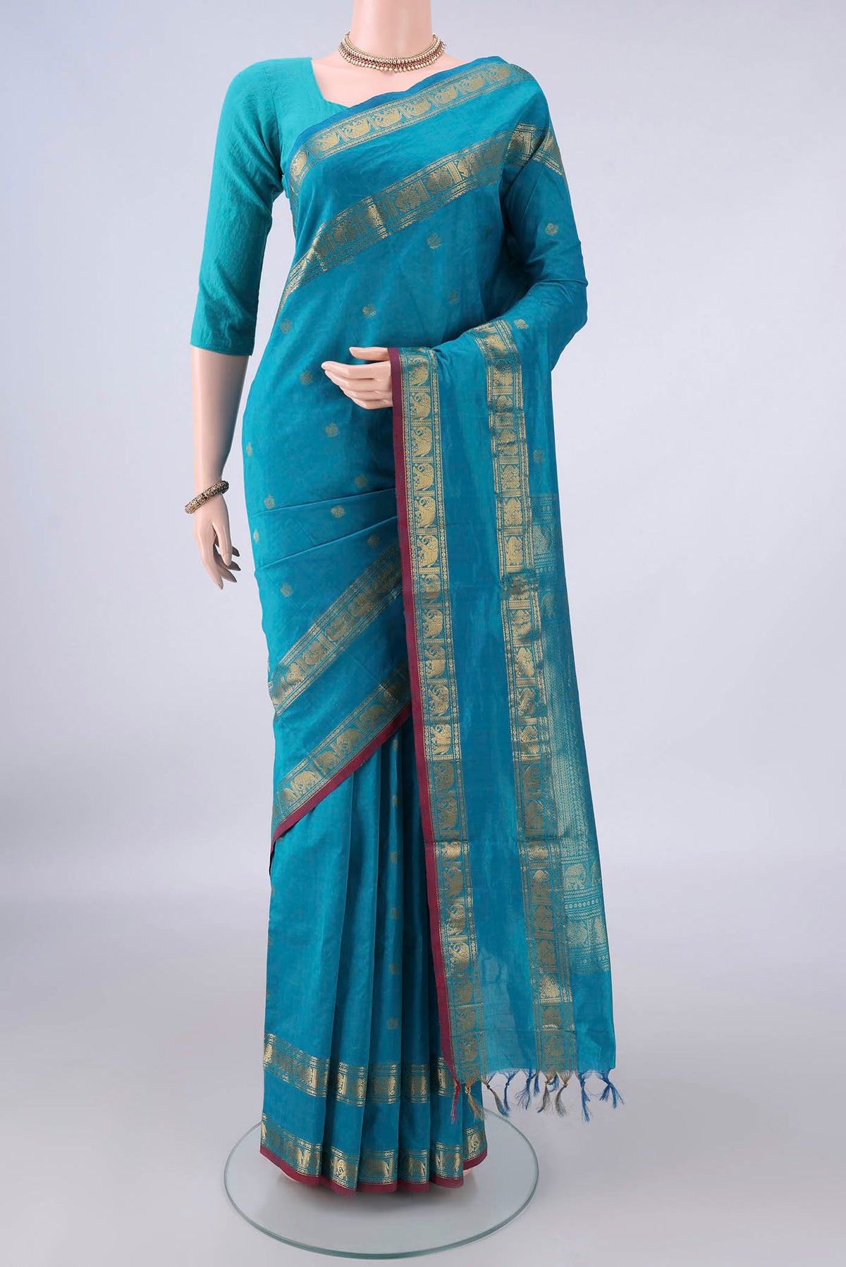 Sea Green Silk Cotton Saree with Zari Butta on the body and Zari Border.  displayed on a mannequin