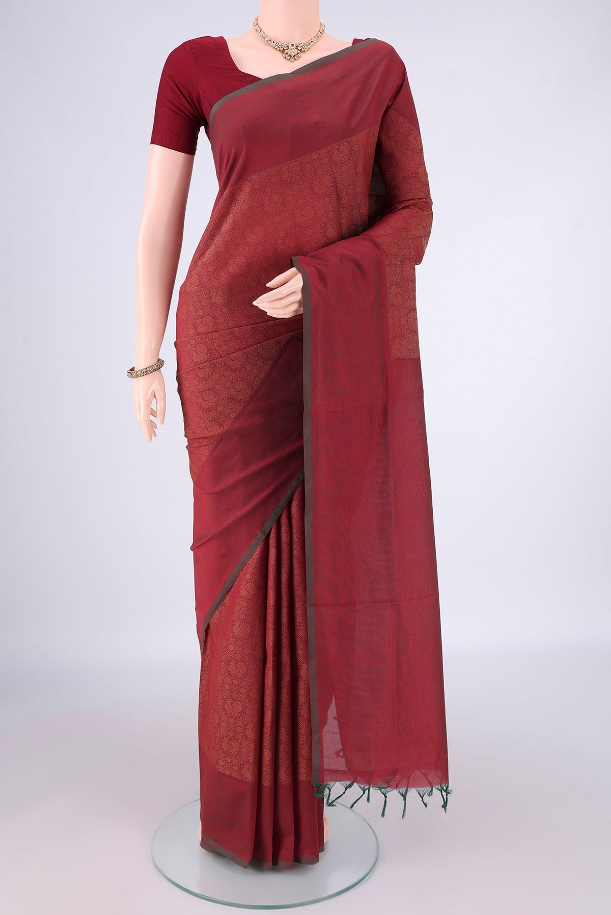 Rust Blended Poly Cotton Saree with Jacquard design on the body and Thread Border.  displayed on a mannequin