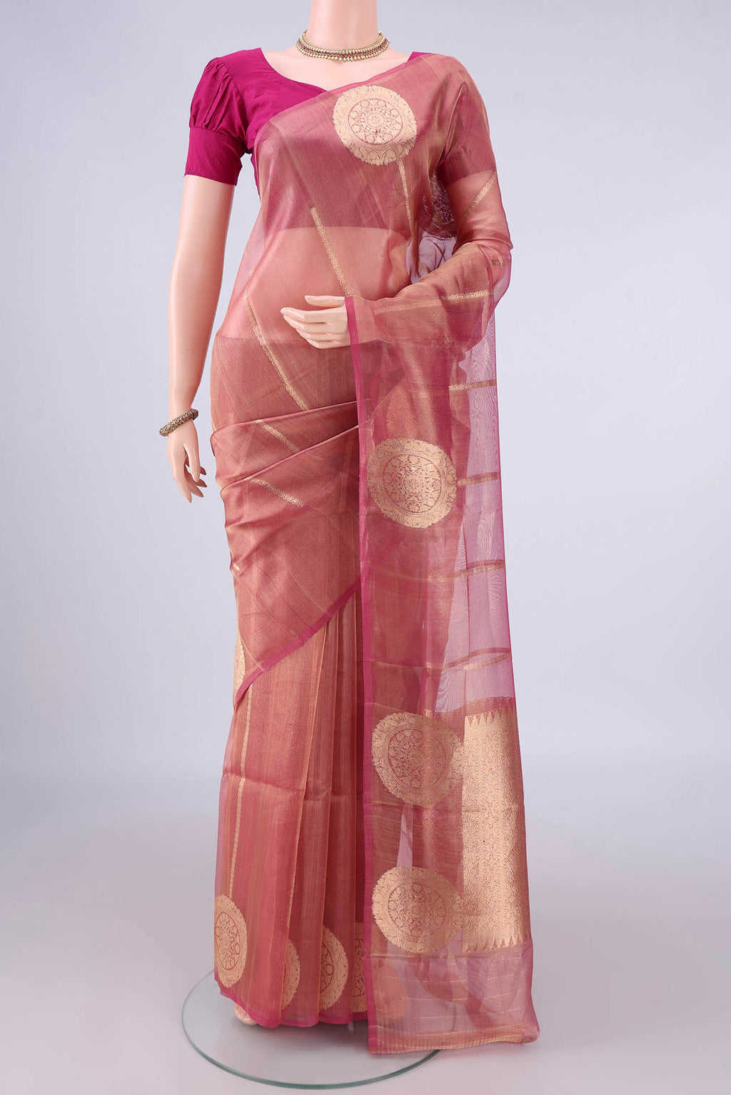 Golden Peach Organza Saree with Stripes on the body and Without Border.  displayed on a mannequin