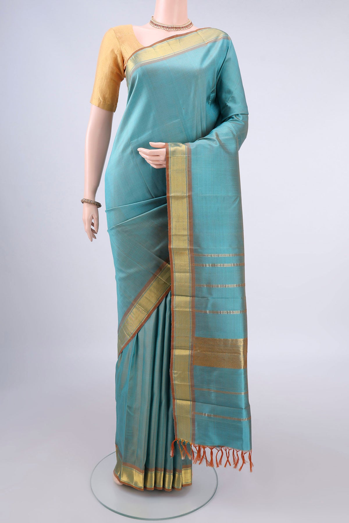 Pure Silk Turquoise Kanjivaram Saree with Zari Butta on the body and Zari Border.  displayed on a mannequin