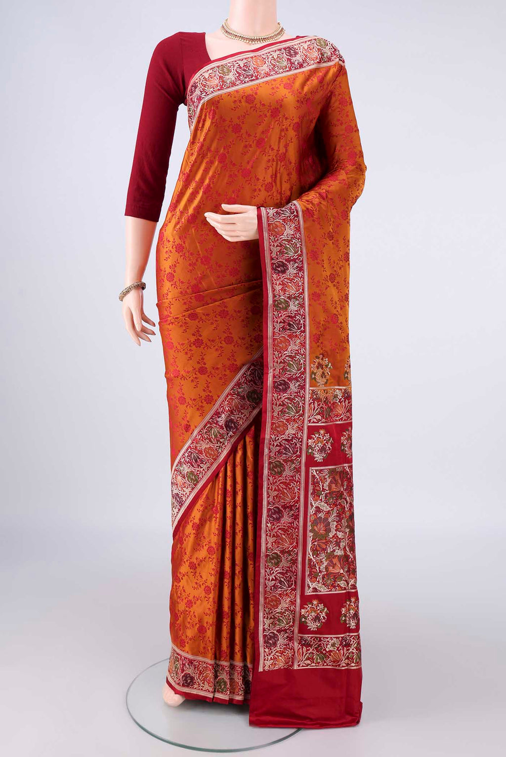 Orange Banarasi Jamavar Saree with Thread Brocade on the body and Zari Border.  displayed on a mannequin